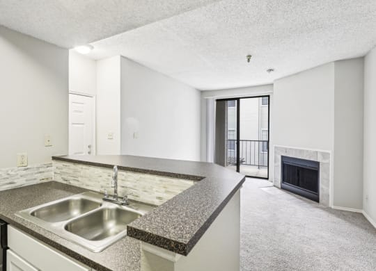 A1 floor plan kitchen with a sink and elevated counter overlooking the fireplace at Jefferson Creek Apartments in Irving, TX.