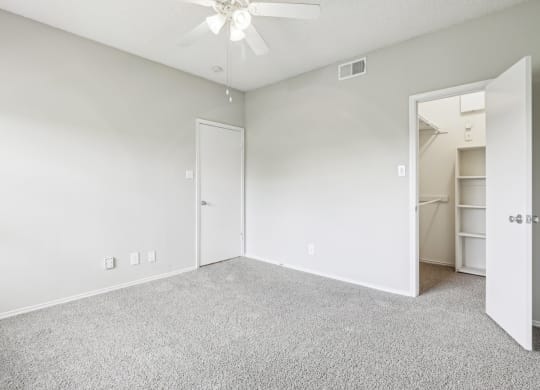 A2 floor plan bedroom with a  walk-in closet and a ceiling fan at Jefferson Creek Apartments in Irving, TX.