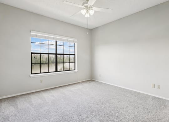 Bedroom 1 in the B1 floor plan with window and a ceiling fan at Jefferson Creek Apartments in Irving, TX.