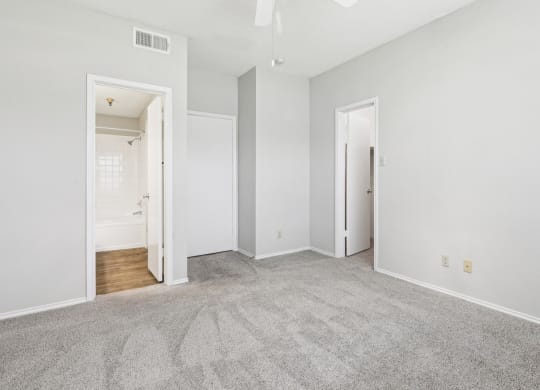 First bedroom at B1 floor plan with walk-in closet and in-room door to bathroom at Jefferson Creek Apartments in Irving, TX.