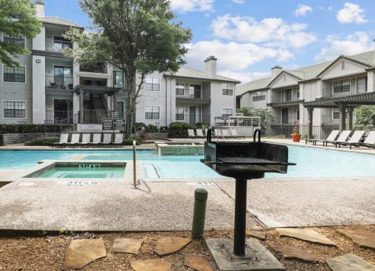a swimming pool and a grill at Jefferson Creek in Irving, TX
