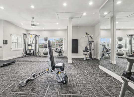 a gym with weights and cardio machines at Jefferson Creek in Irving, TX