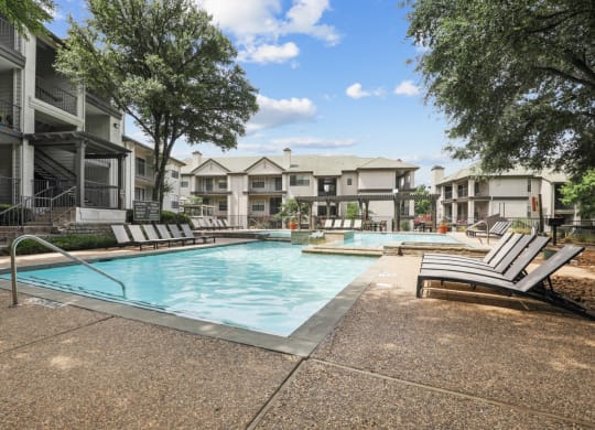 a resort style pool and lounge chairs at Jefferson Creek in Irving, TX