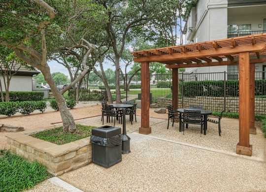 A patio area for al fresco dining with tables and chairs at Jefferson Place Apartments in Irving, TX