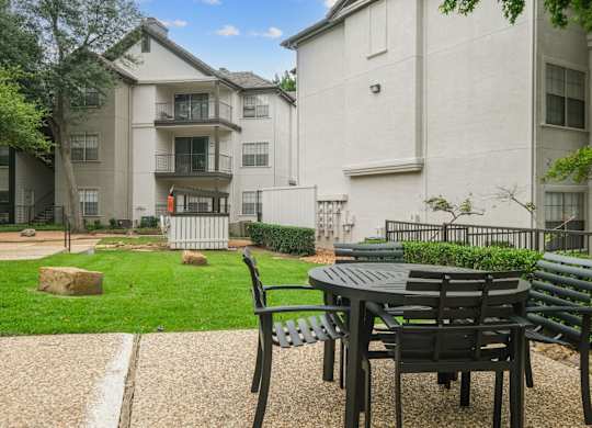 Al fresco dining table with apartment buildings in the back at Jefferson Place apartments in Irving, TX