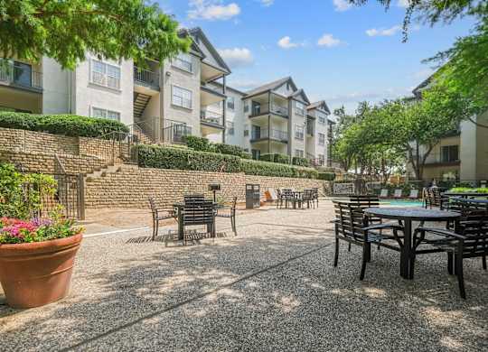 An al fresco dining patio with tables and chairs at Jefferson Place Apartments in Irving, TX