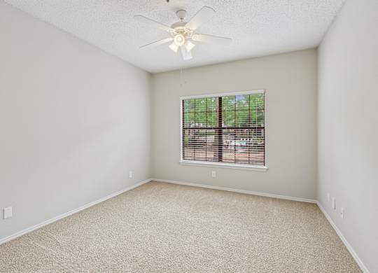 B2 bedroom with a ceiling fan and a window at Jefferson Place Apartments in Irving, TX