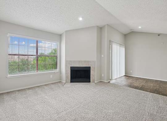 B2 living room with a fireplace and a large window at Jefferson Place Apartments in Irving, TX