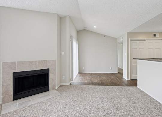 B2 carpeted living room with white walls and a fireplace at Jefferson Place Apartments in Irving, TX