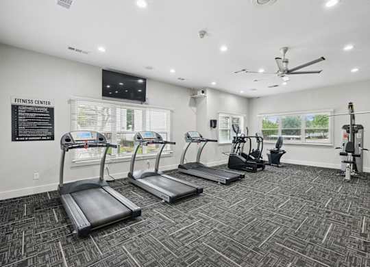 A fitness center with treadmills and strength training machines at Jefferson Place Apartments in Irving, TX