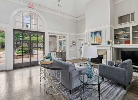 Resident lounge area with grey couches and a glass table at Jefferson Place Apartments in Irving, TX