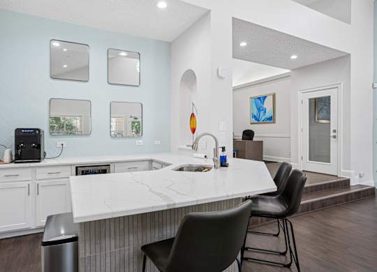 Clubhouse kitchen with a white countertop and a black chair.