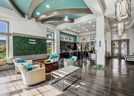 A large, well-lit lobby with a green wall and a variety of seating options.