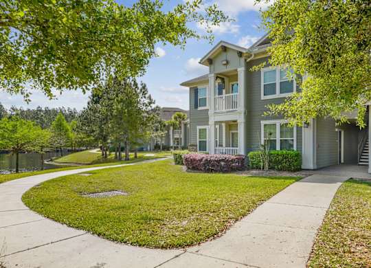 A residential building with a green lawn in front.