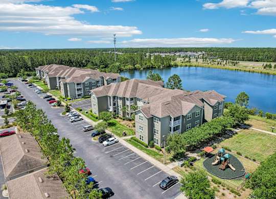 A view of a parking lot with cars and apartment buildings.
