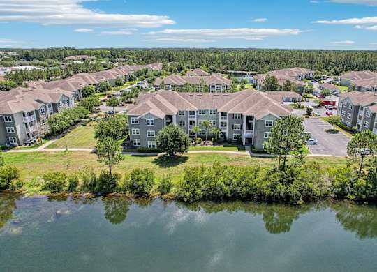 A large body of water is in front of a cluster of houses.