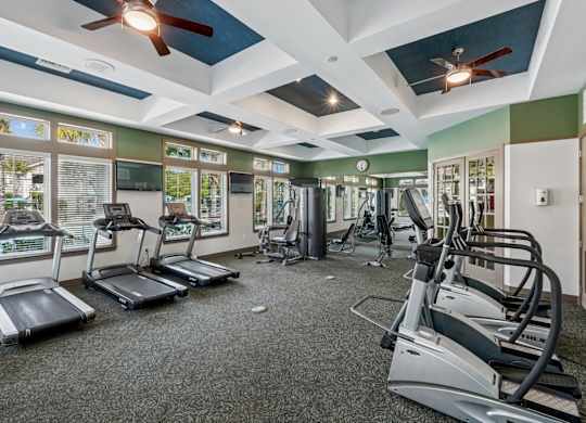 A gym with treadmills, elliptical machines, and other exercise equipment.