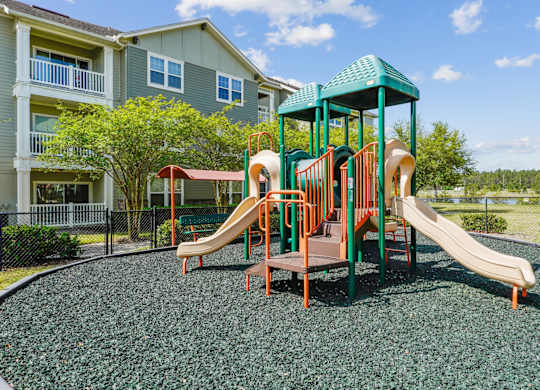 A playground with a green slide and a brown slide.