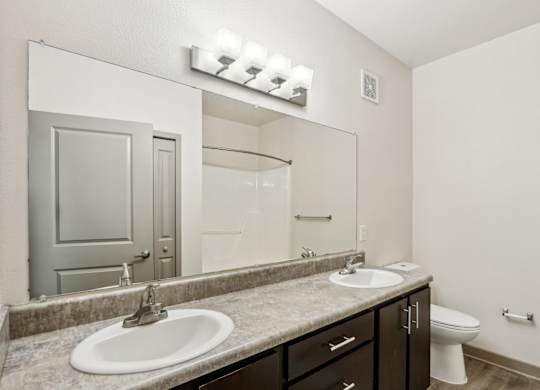 Royal Palm bathroom with a sink, vanity lights, mirror, and toilet at Oakleaf Plantation Apartments in Jacksonville, FL
