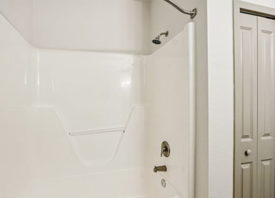 A white bathroom with a shower and a door.