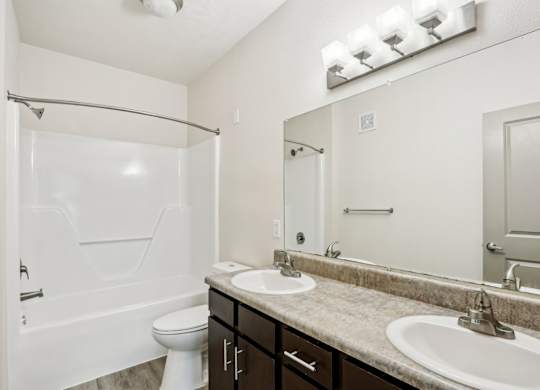 A white bathroom with a toilet, sink, and shower.