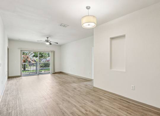 Royal Palm living room with a sliding glass door leading to a private patio at Oakleaf Plantation apartments in Jacksonville, FL.