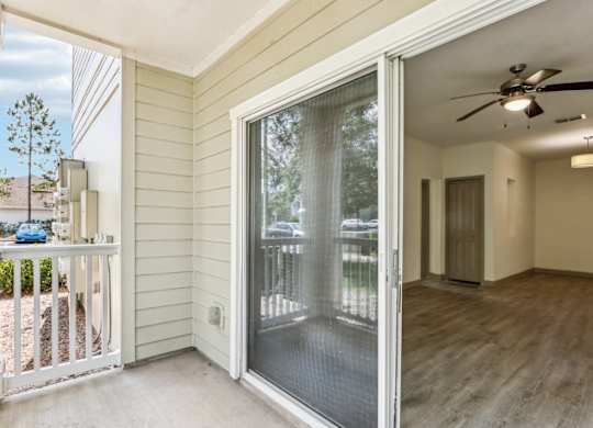 Fenced in Royal Palm patio with sliding glass doors leading inside at Oakleaf Plantation Apartments in Jacksonville, FL