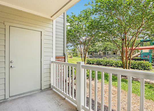 A Royal Palm fenced in patio looks out at the lush greenery at Oakleaf Plantation Apartments in Jacksonville, FL