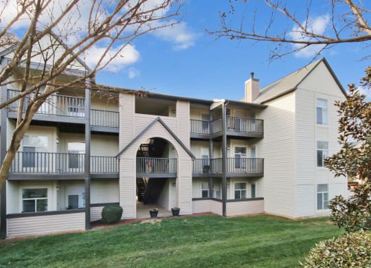an exterior view of an apartment building with a lawn