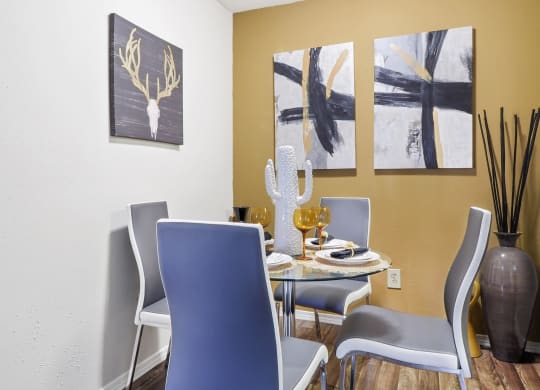 a dining room with a table and chairs and paintings on the wall