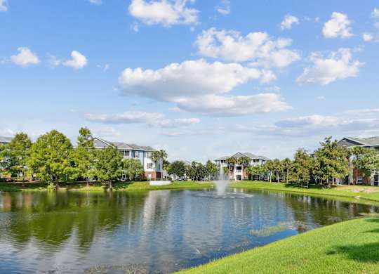 A serene pond surrounded by lush greenery at Wynnfield Lakes Apartments in Jacksonville, FL