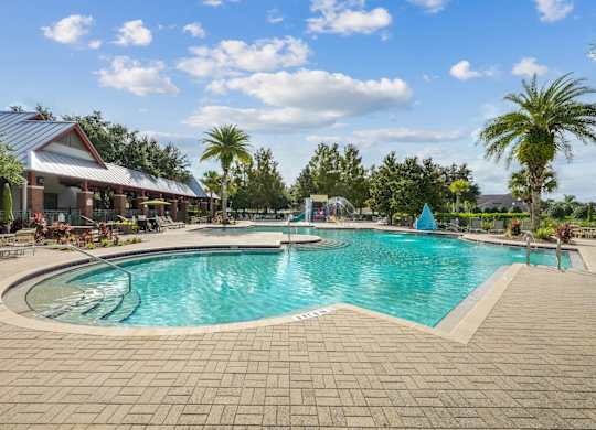 A large outdoor swimming pool surrounded by a brick patio and a covered pavilion at Wynnfield Lakes Apartments in Jacksonville, FL