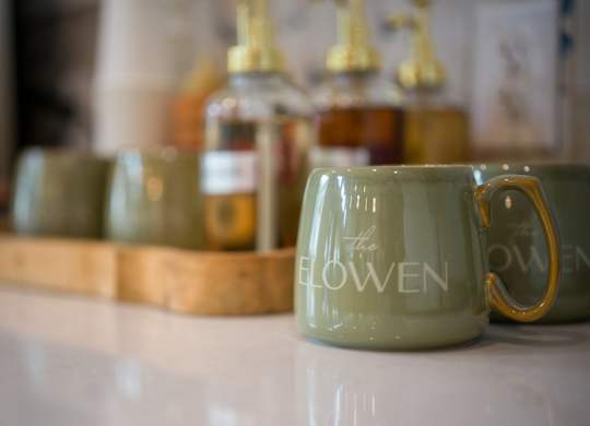 A green mug with the word "flowen" written on it.
