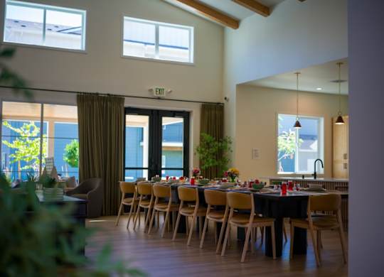 A dining room with a table set for a meal.