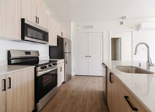 A kitchen with wooden cabinets and a stainless steel sink.