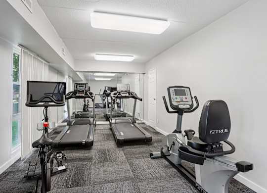 A gym with treadmills, exercise bikes, and elliptical machines.