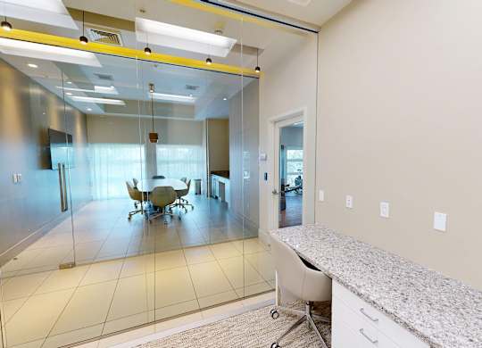 A conference room with a glass wall and a white table.