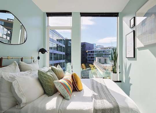 A bedroom with a large bed and a view of the city.