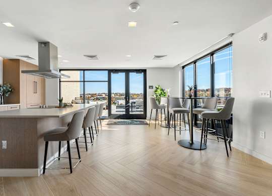 A modern kitchen with a long island and chairs.