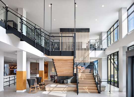 A modern interior with a staircase and a glass railing.