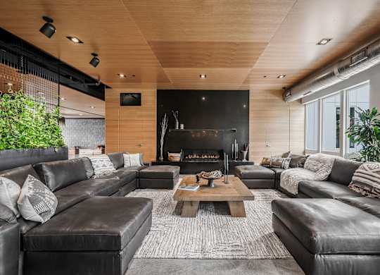 A modern living room with a fireplace and leather furniture.