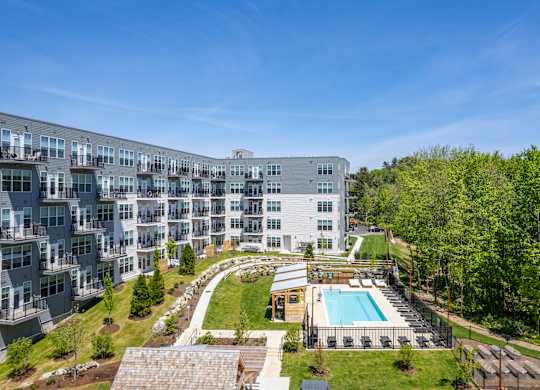 A large apartment complex with a pool and a landscaped courtyard.