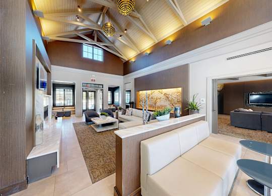 A modern living room with a white sofa and a wooden ceiling.