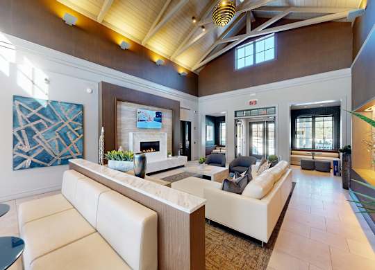 A modern living room with a white sofa and a glass table.