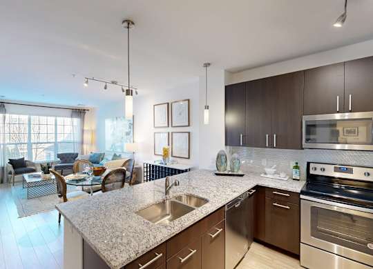 A modern kitchen with stainless steel appliances and a marble countertop.