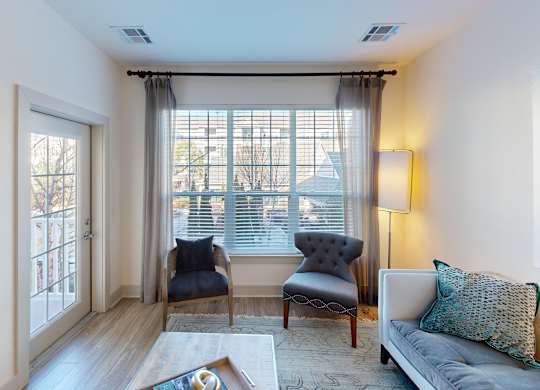 A living room with a grey couch, two chairs, and a coffee table.