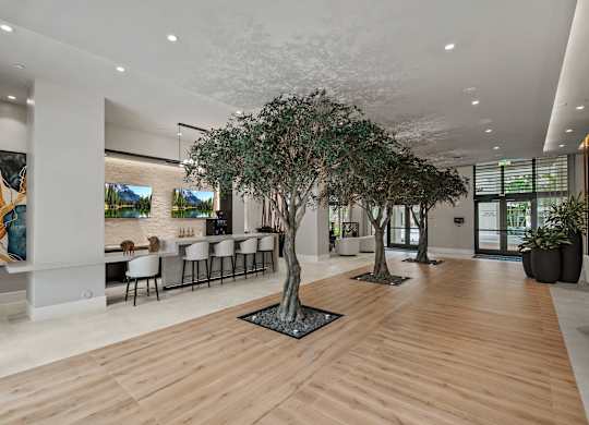 A modern office lobby with a long wooden floor and a row of chairs.