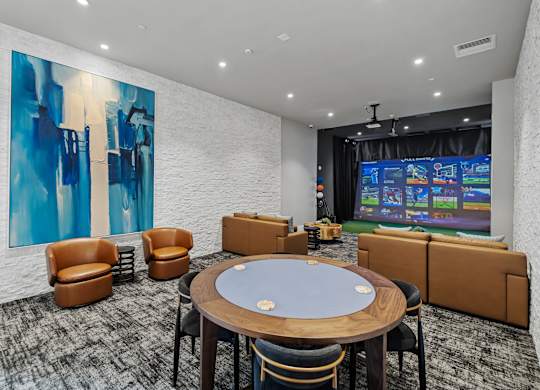 A room with a poker table and chairs and a large painting on the wall.