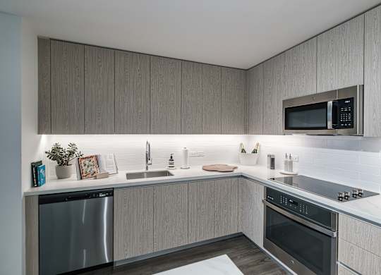 A modern kitchen with a stainless steel dishwasher and oven.