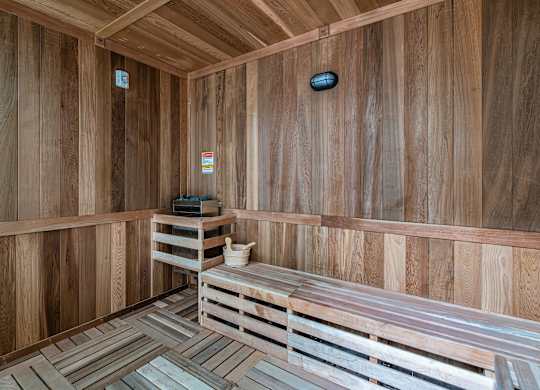 A wooden sauna with benches and a heater.